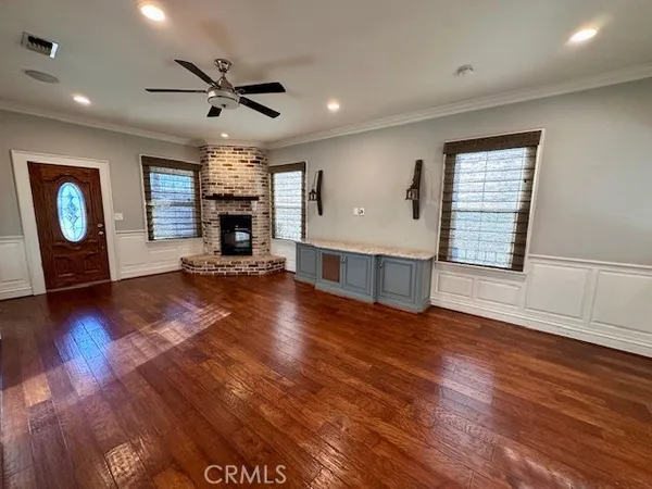 a view of a livingroom with fireplace wooden floor and furniture
