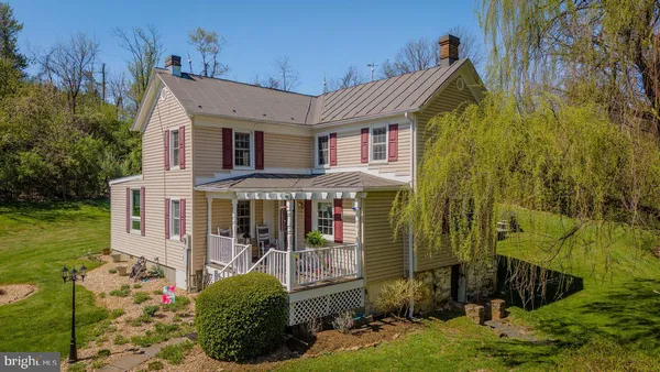 a view of a house with a yard and potted plants