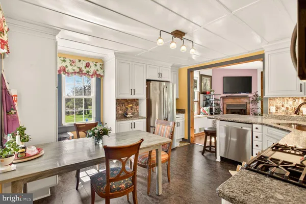 a dining room with stainless steel appliances kitchen island granite countertop furniture and a kitchen view