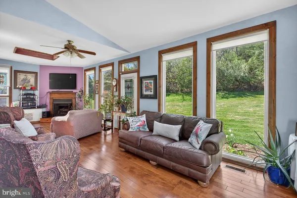 a living room with furniture large windows and a fireplace