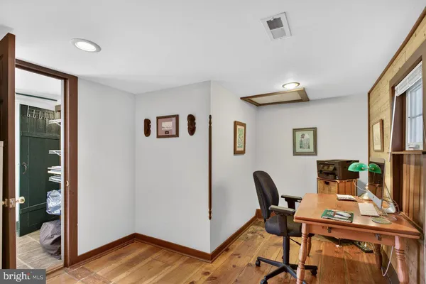 a view of a workspace with wooden floor and white cabinet