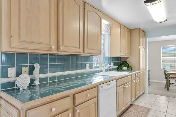 a kitchen with granite countertop a sink a stove and cabinets