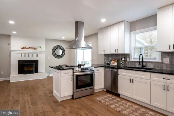 a kitchen with granite countertop a stove top oven sink and cabinets