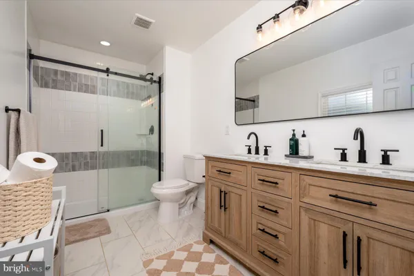 a bathroom with a sink a toilet and shower