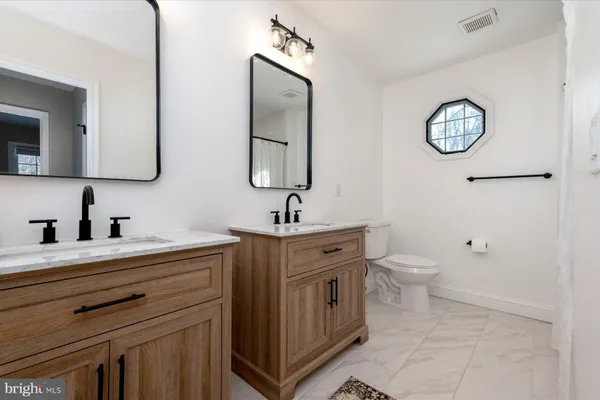a bathroom with a toilet a sink and mirror