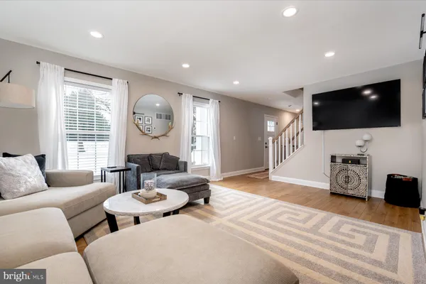 a living room with furniture a flat screen tv and a window