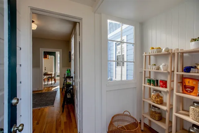 a bedroom with bed and a lamp on dresser