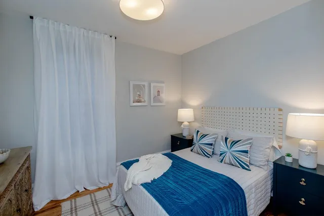 a bedroom with a bed and a lamp on table