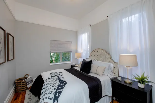 a view of a backyard with couches table and chairs with plants and wooden fence