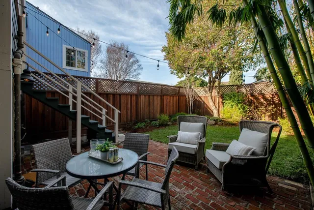 a view of backyard with large tree and wooden fence