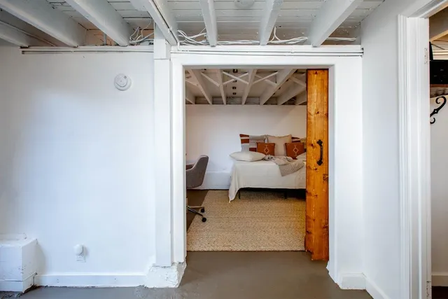 a bedroom with a bed and wooden floor