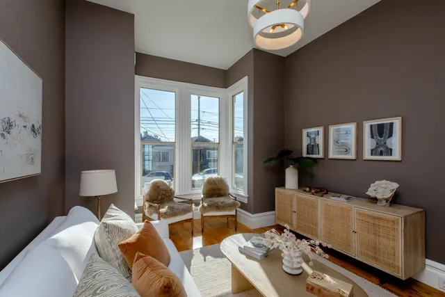 a living room with furniture flowerpot and wooden floor