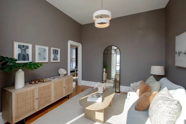 a living room with furniture and a mirror