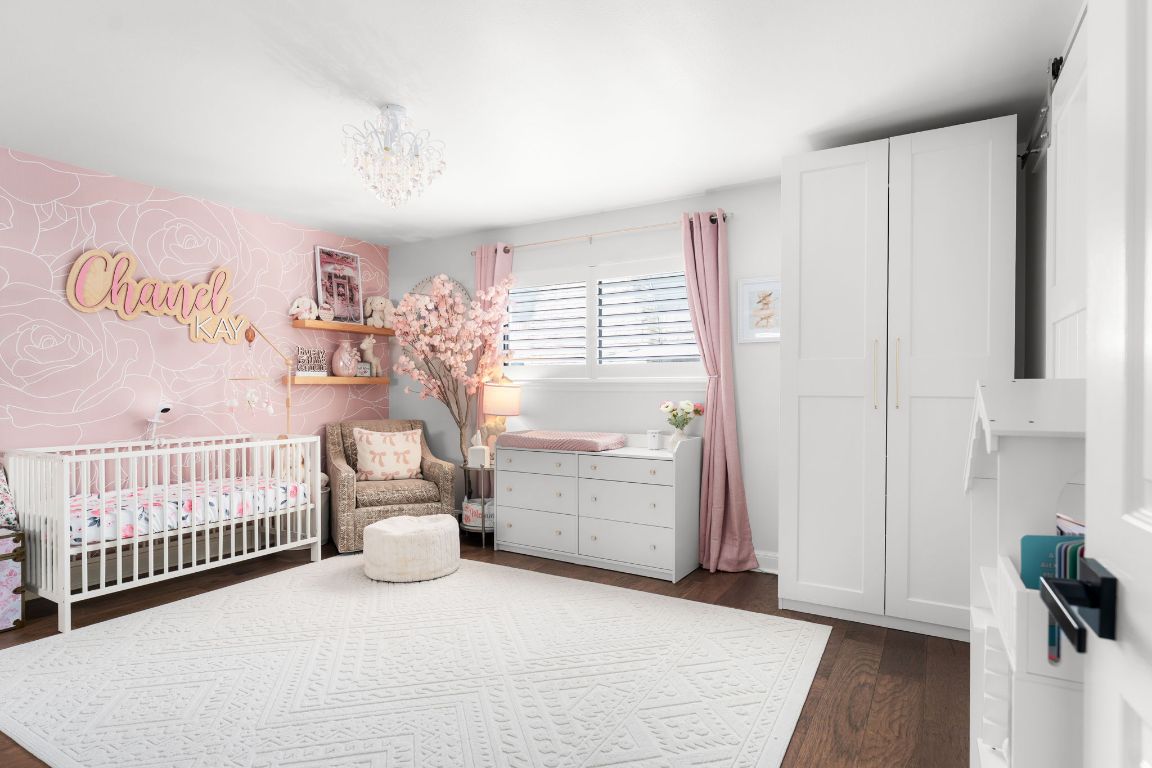 10218 Braemar Drive Austin, TX 78747 - Photo 22 of 34 Bedroom with a nursery area, dark wood-type flooring, and a chandelier
