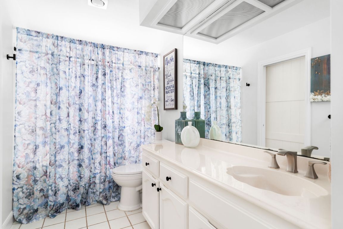 10218 Braemar Drive Austin, TX 78747 - Photo 25 of 34 Full bath with vanity, a shower with shower curtain, and light tile patterned floors