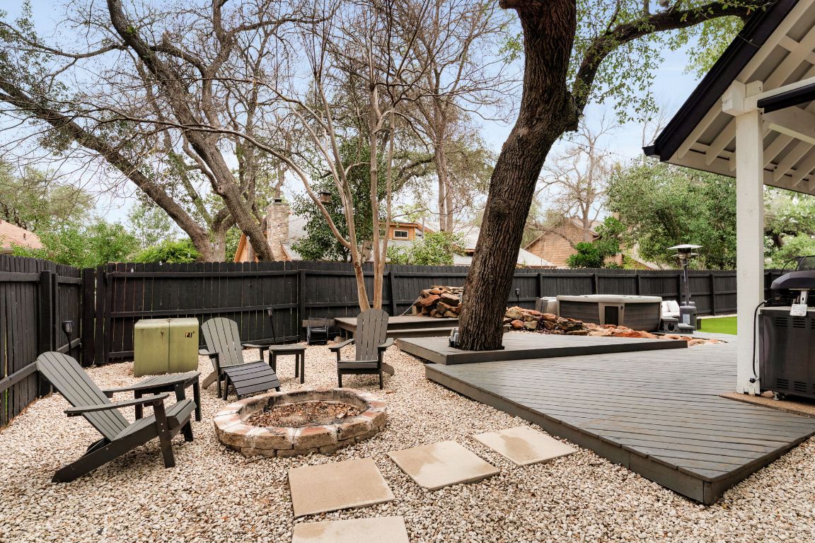 10218 Braemar Drive Austin, TX 78747 - Photo 31 of 34 Fenced backyard with an outdoor fire pit, a deck, and a patio