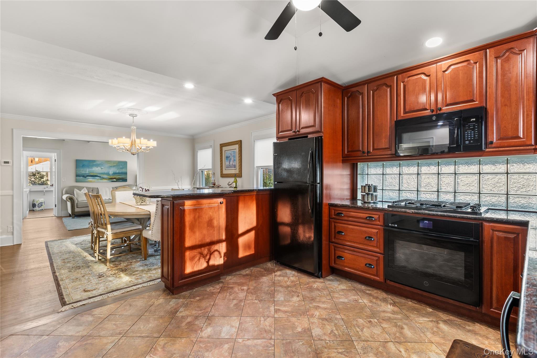 26 Community Road Bay Shore, NY 11706 - Photo 9 of 27 a kitchen with stainless steel appliances granite countertop a stove top oven a sink dishwasher a dining table and chairs with wooden floor