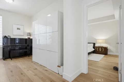 a large bed in a white room with a lamp