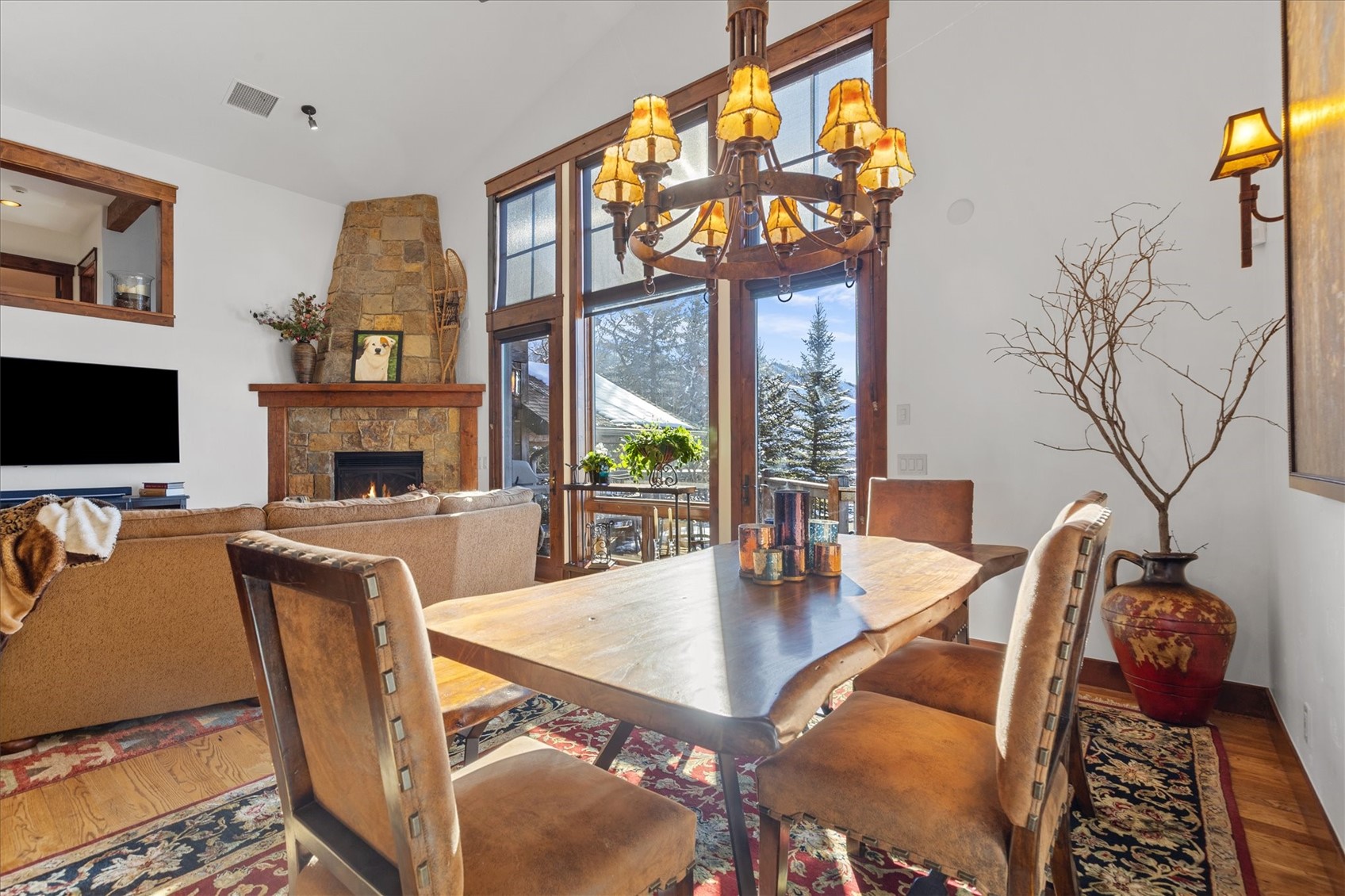 2324 Glacier Ridge, Unit B Steamboat Springs, CO 80487 - Photo 12 of 46 Dining room with a fireplace, a chandelier, and hardwood / wood-style floors