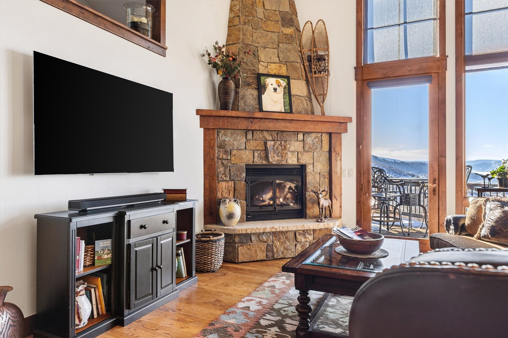 2324 Glacier Ridge, Unit B Steamboat Springs, CO 80487 - Photo 16 of 46 Living area with light wood finished floors, a fireplace, a high ceiling, and plenty of natural light