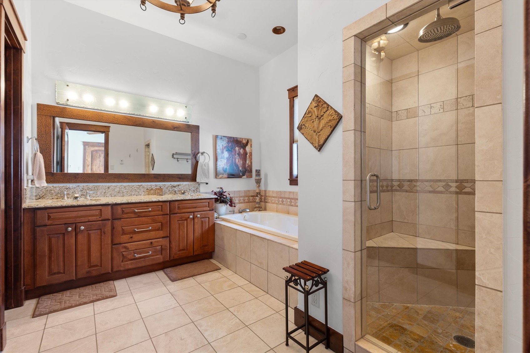 2324 Glacier Ridge, Unit B Steamboat Springs, CO 80487 - Photo 32 of 46 Full bath featuring a stall shower, double vanity, a garden tub, and light tile patterned floors
