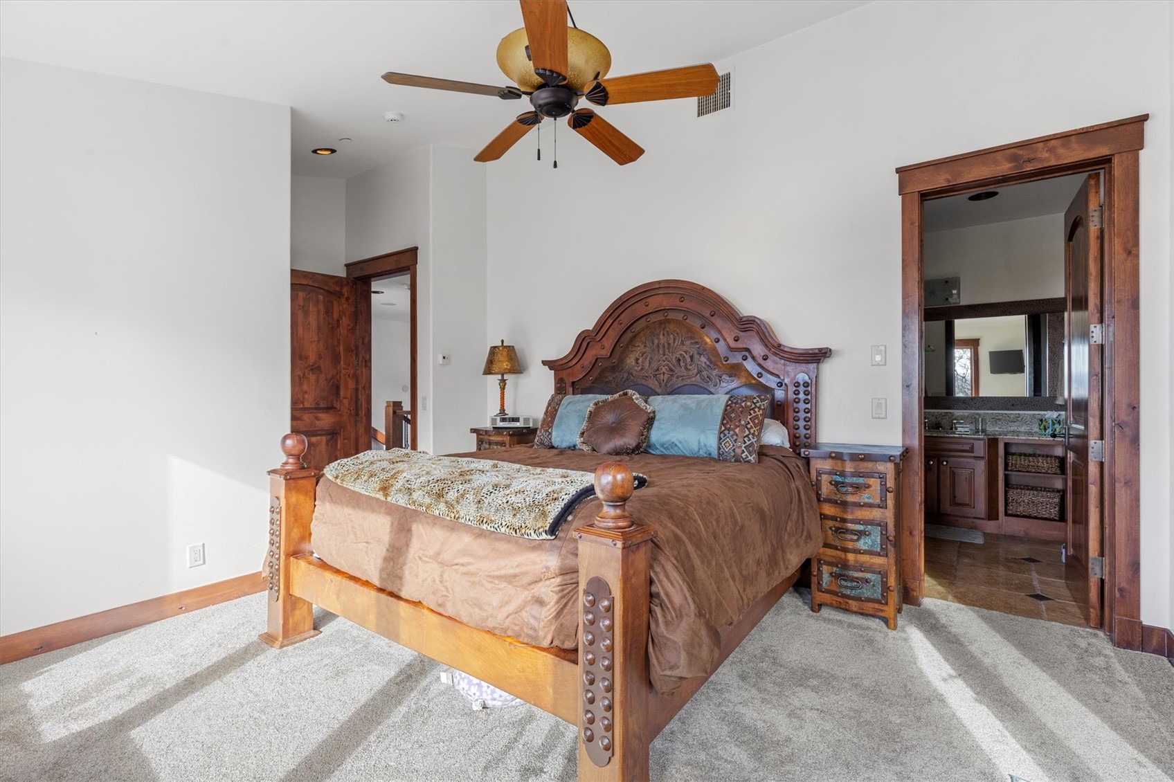 2324 Glacier Ridge, Unit B Steamboat Springs, CO 80487 - Photo 35 of 46 Bedroom featuring ensuite bath, light carpet, and a ceiling fan