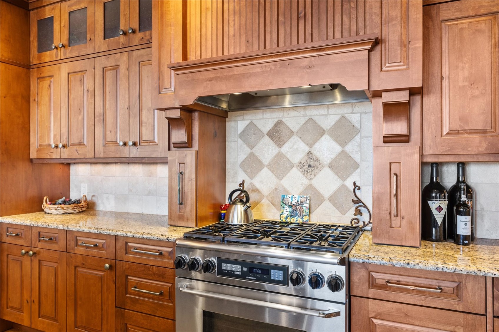 2324 Glacier Ridge, Unit B Steamboat Springs, CO 80487 - Photo 9 of 46 Kitchen with gas stove, light stone countertops, and brown cabinetry