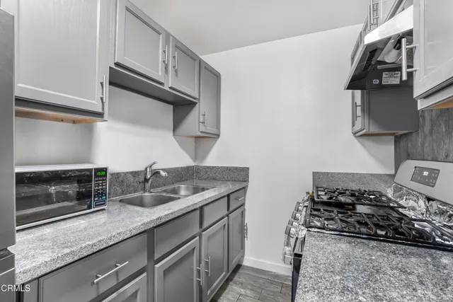 a kitchen with stainless steel appliances granite countertop a sink stove and cabinets