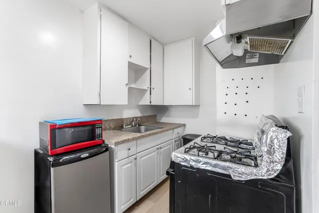 a kitchen with granite countertop white cabinets and white appliances