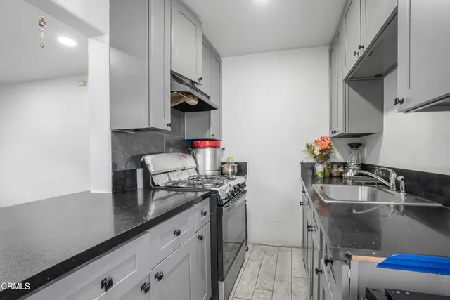 a kitchen with stainless steel appliances granite countertop a sink stove and refrigerator