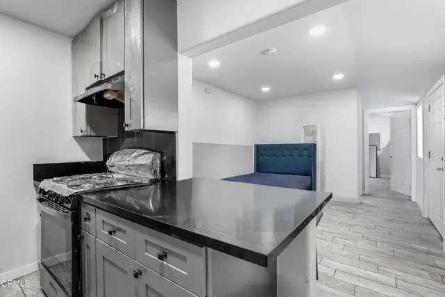 a kitchen with stainless steel appliances granite countertop a sink a stove and a refrigerator