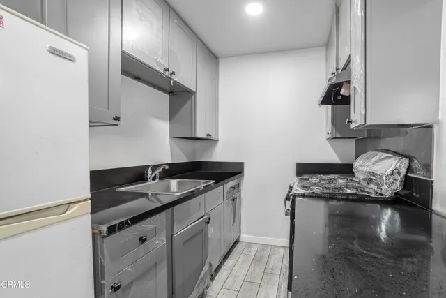 a kitchen with granite countertop a sink a stove and cabinets