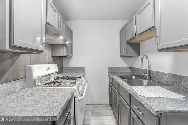 a kitchen with stainless steel appliances granite countertop a sink stove and cabinets