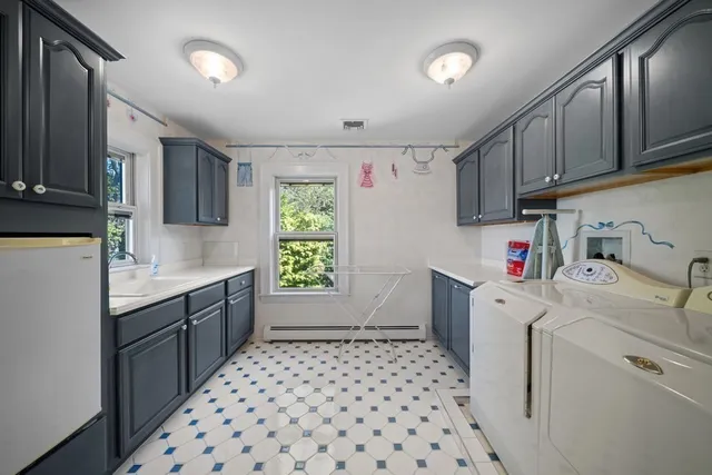 a kitchen with a sink a stove cabinets and wooden floor