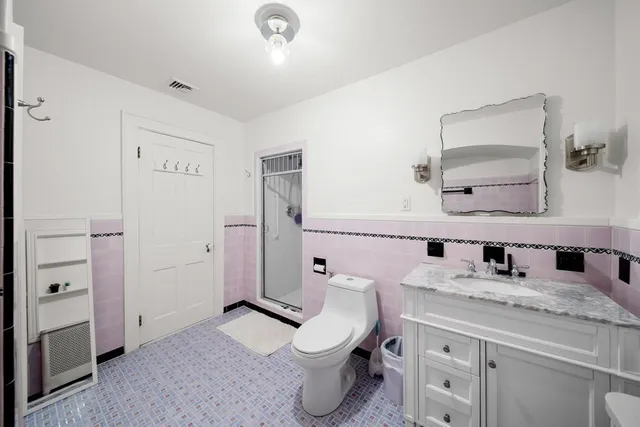 a bathroom with a toilet sink and mirror