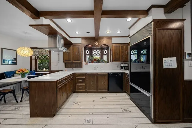 a large kitchen with a large counter top stainless steel appliances and cabinets
