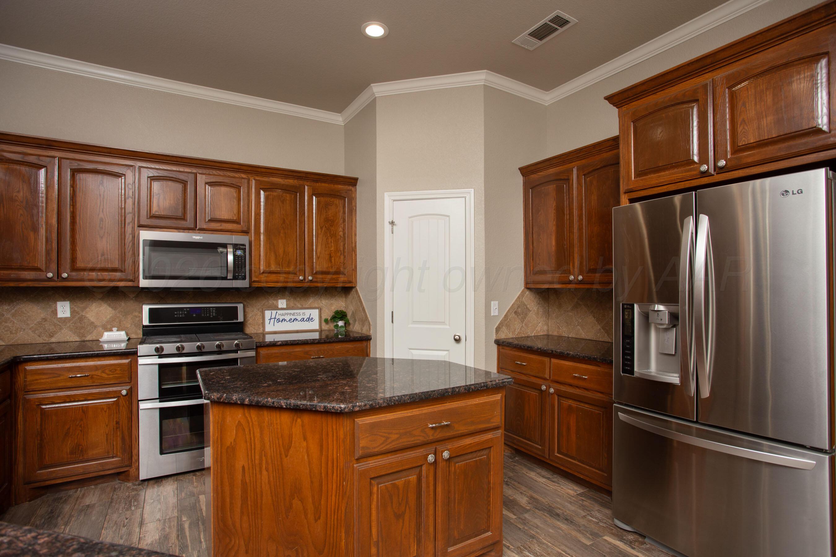 18400 Sundancer Lane Bushland, TX 79124 - Photo 12 of 58 a kitchen with granite countertop a refrigerator stove and oven