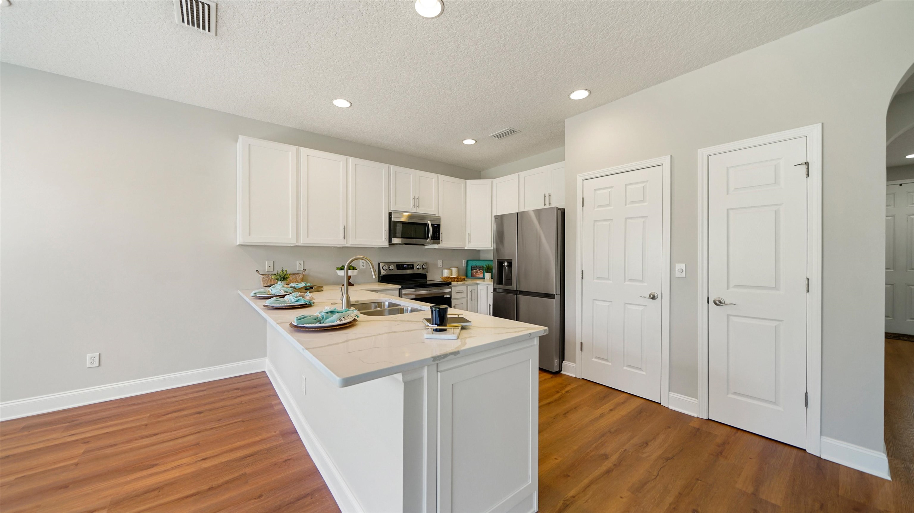 18 Amistad Drive, Unit 18 St. Augustine, FL 32086 - Photo 11 of 36 a kitchen with stainless steel appliances granite countertop a sink stove and wooden floor