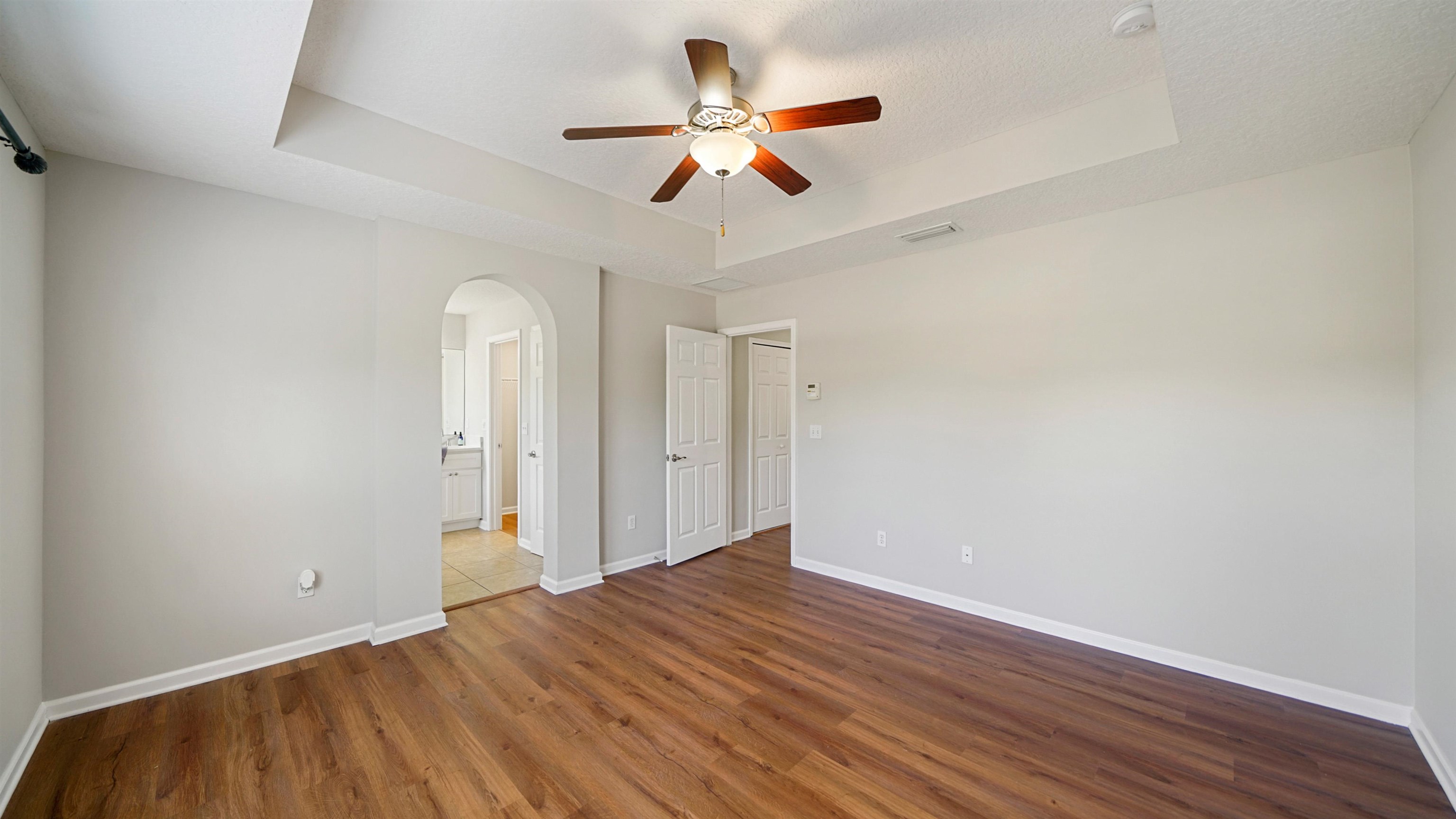 18 Amistad Drive, Unit 18 St. Augustine, FL 32086 - Photo 16 of 36 an empty room with wooden floor ceiling fan and windows