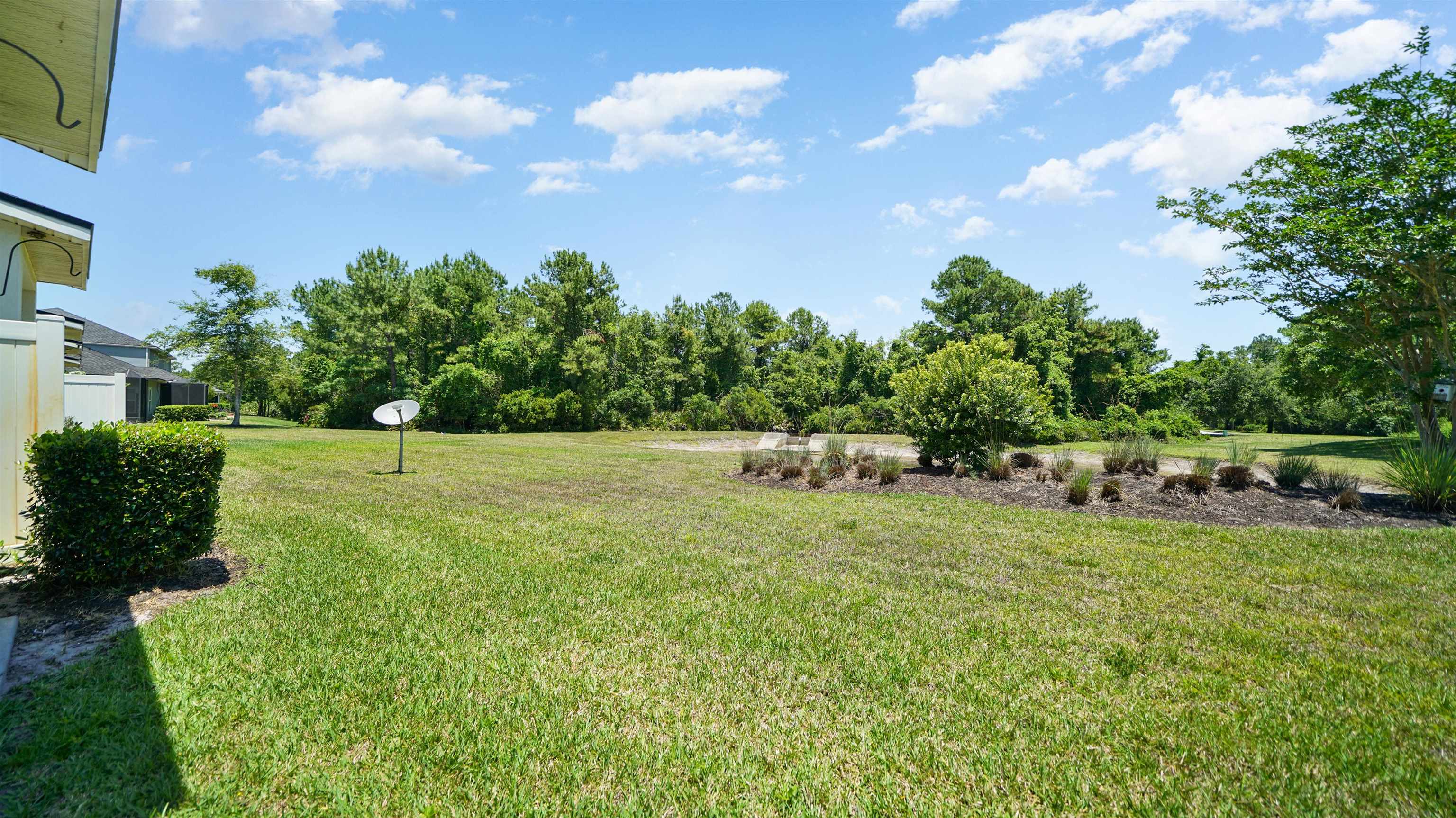 18 Amistad Drive, Unit 18 St. Augustine, FL 32086 - Photo 29 of 36 a backyard of a house with lots of green space and garden
