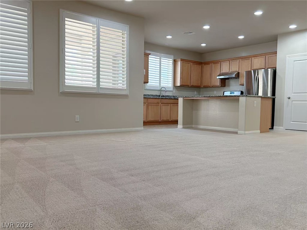 146 Tree Shot Court Las Vegas, NV 89113 - Photo 18 of 18 An open floor plan seamlessly connects the kitchen and living area, featuring bright recessed lighting.