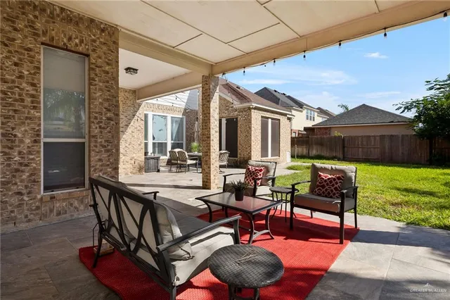 a view of a patio with table and chairs with wooden floor and fence
