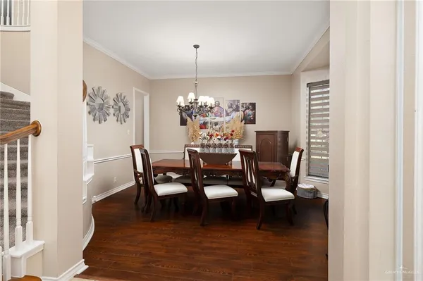 a dining room with furniture a chandelier and wooden floor