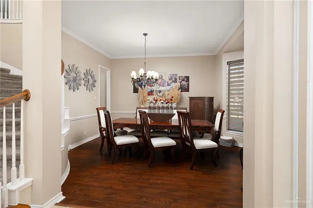 a dining room with furniture a chandelier and wooden floor