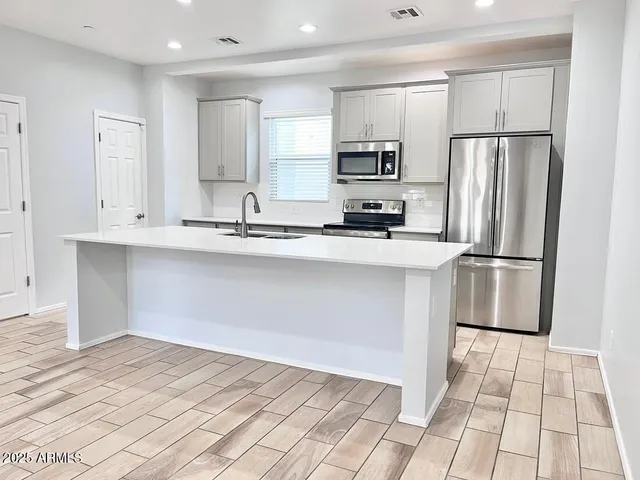 a kitchen with stainless steel appliances a refrigerator sink and microwave