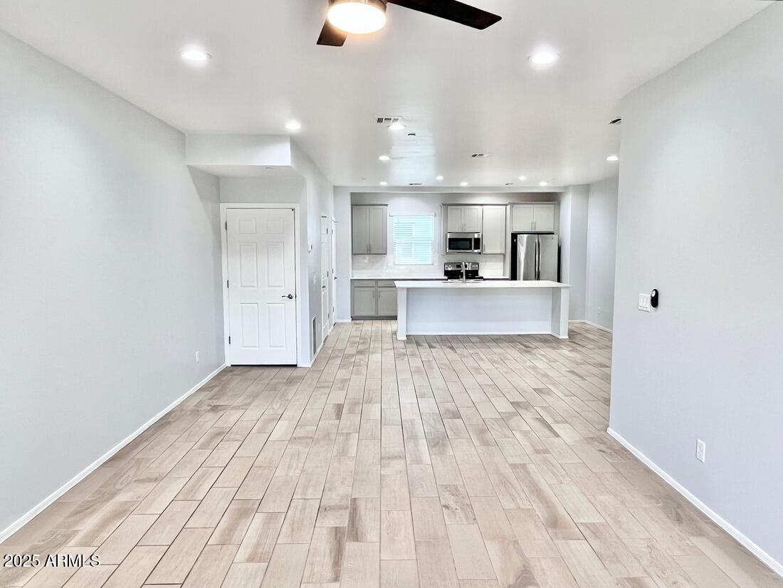 3434 North Longview Avenue, Unit 13 Phoenix, AZ 85014 - Photo 14 of 53 a large kitchen with kitchen island a stove a sink dishwasher a refrigerator and white cabinets with wooden floor