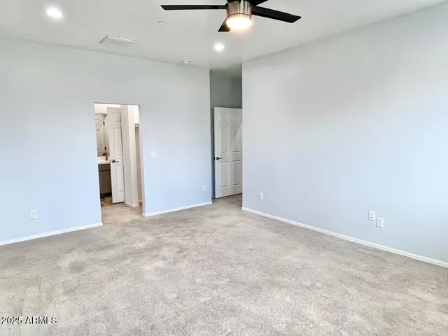 an empty room with a ceiling fan and window