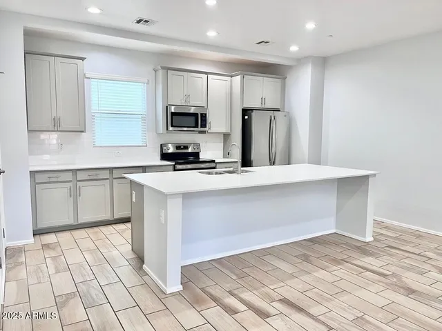 a kitchen with stainless steel appliances a refrigerator sink and microwave