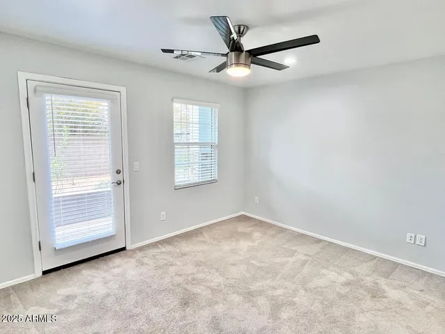 an empty room with closet and a ceiling fan