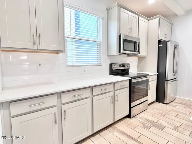 a kitchen with white cabinets stainless steel appliances and sink